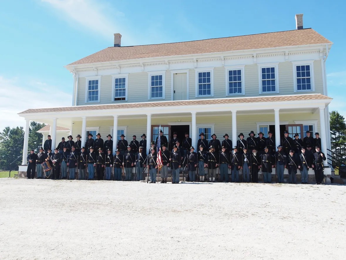 Company E, 2nd Wisconsin Volunteer Infantry Civil War reenactors group photograph in front of the 1855 stagecoach inn at Pinecrest Historical Village, 2026